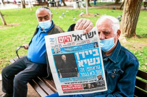 Un Israélen présente la Une d’un quotidien national annonçant la victoire de Joe Bien à la présidentielle américaine. (Photo AFP)
