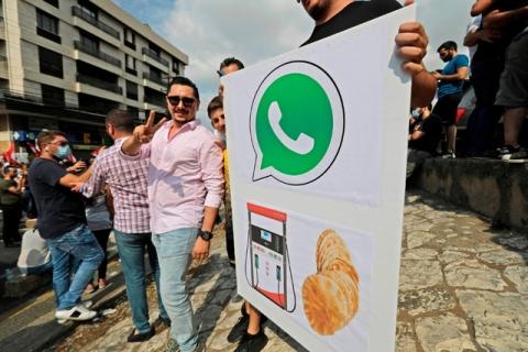 Des manifestants libanais brandissent des pancartes lors d'une manifestation.