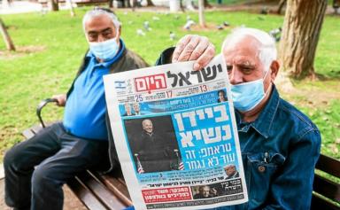 Un Israélen présente la Une d’un quotidien national annonçant la victoire de Joe Bien à la présidentielle américaine. (Photo AFP)